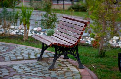 Empty bench in park during rainy season