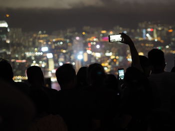 Silhouette people photographing at music concert
