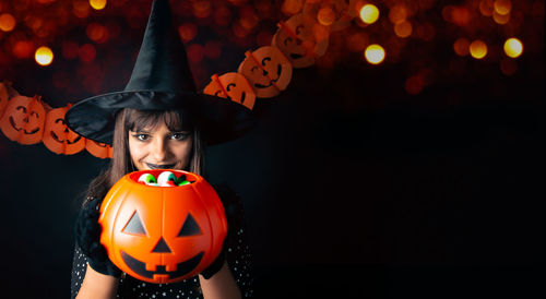Rear view of woman wearing hat standing against illuminated christmas