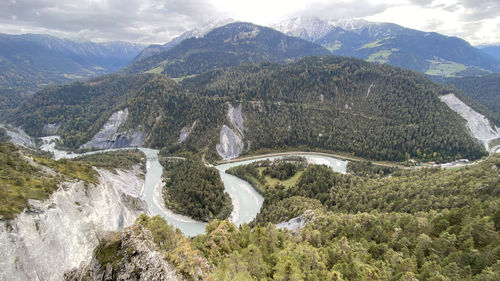 Scenic view of river amidst mountains against sky