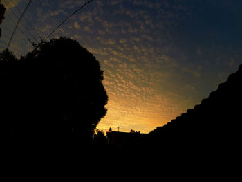 Low angle view of silhouette built structure against sky