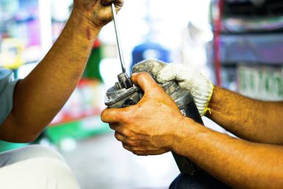 Cropped hands of repairmen holding equipment