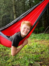 Portrait of smiling boy laying in hammock 