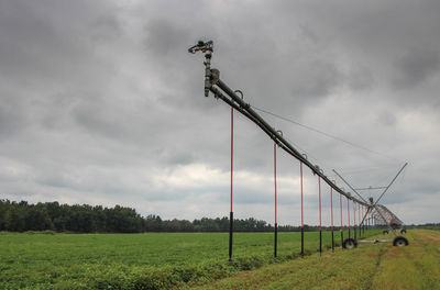 Wind turbines on field against sky