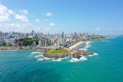 Panoramic view of sea and buildings against blue sky