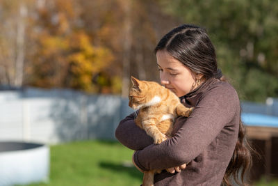 Portrait of young woman with ginger cat