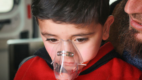 Close-up of boy wearing nebulizer at hospital