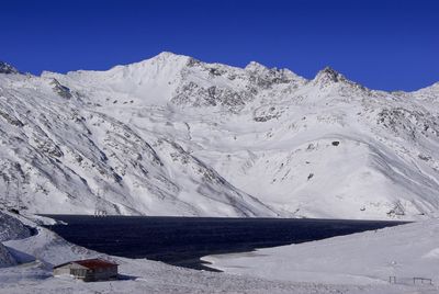 Scenic view of snowcapped mountains against clear blue sky