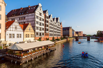 Boats in canal amidst buildings in city