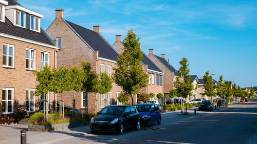 Cars on street in city against sky