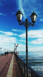 Street light by sea against sky