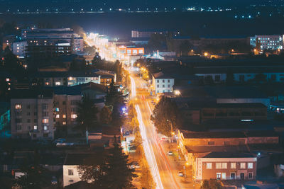 High angle view of illuminated street amidst buildings at night