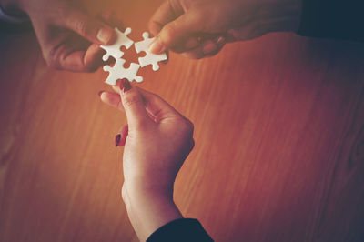 Close-up of man holding hands on table