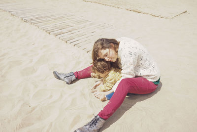 High angle view of woman resting on sand at beach