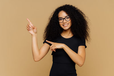 Portrait of a smiling young woman against gray background