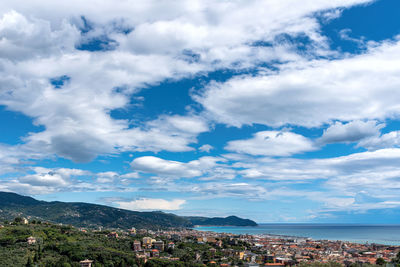 Aerial view of townscape and mountains against sky