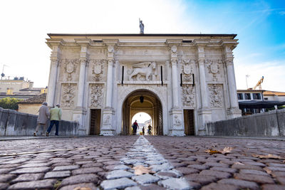 Treviso porta san tomaso a with passing  people during sunny day, view from street floor - italy