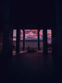 Silhouette of building by sea against sky during sunset