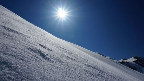 Low angle view of snow covered landscape against clear sky