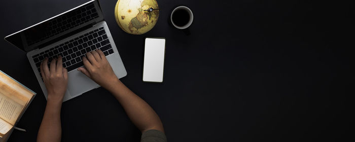 Midsection of woman holding coffee cup on table