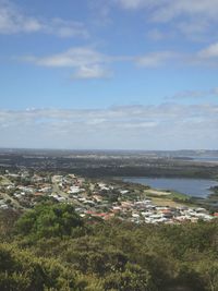 High angle view of townscape by sea against sky