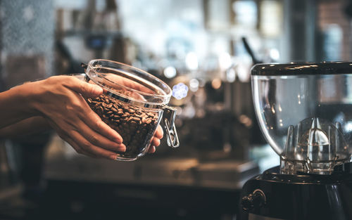 Coffee shop owner show quality coffee beans that are roasted and cooked, in a glass jar