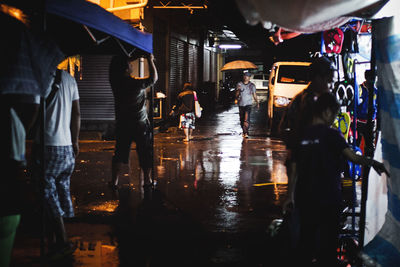 People on market street during monsoon at night