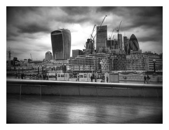 Buildings in city against cloudy sky