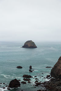 Scenic view of rocks in sea against clear sky