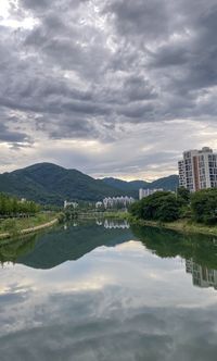 Scenic view of lake by buildings against sky