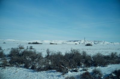 Scenic view of snow field against blue sky