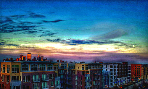 Buildings against cloudy sky at sunset