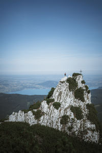 Scenic view of man on rock against sky