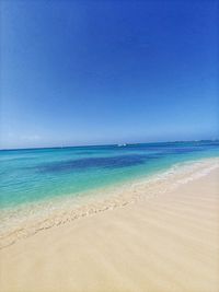 Scenic view of beach against clear blue sky