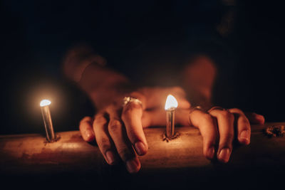 Close-up of hand holding lit candles