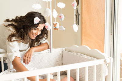 Mother looking at son in crib