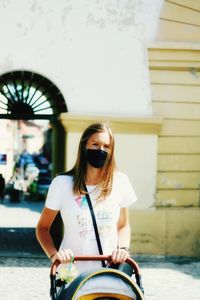 Portrait of young woman with coronavirus mask walking on the street