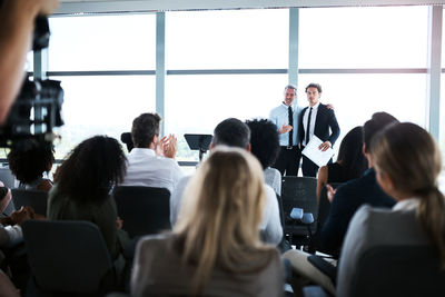 Rear view of people sitting in meeting