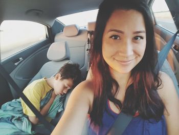 Portrait of smiling young woman sitting in car