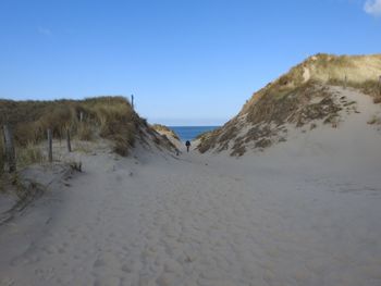 Scenic view of beach against clear blue sky