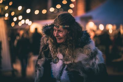 Mature woman wearing fur coat at night