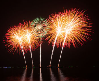 Firework display by river at night