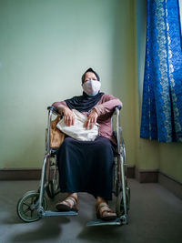 Full length of man sitting on wall