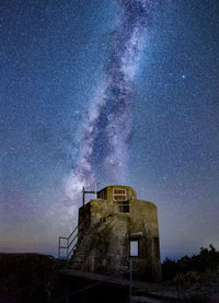 Low angle view of building against milky way