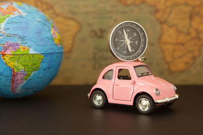 Close-up of toy car and navigational compass on table