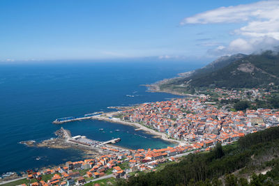 High angle view of townscape by sea against sky