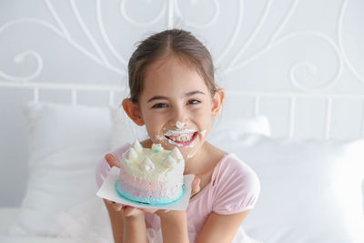 Portrait of a smiling girl holding indoors