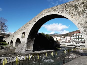 Arch bridge over river against sky