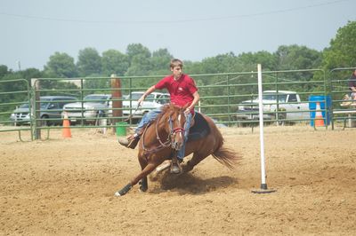 Young man riding horse during pole bending