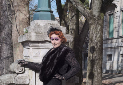 Portrait of woman with face make up standing by tree outdoors